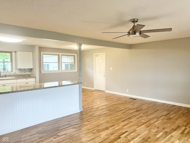 kitchen featuring light wood-type flooring, a sink, white cabinetry, and a ceiling fan