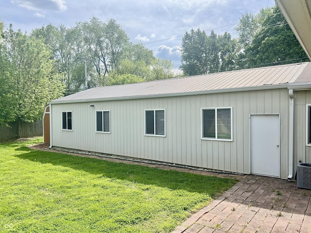 view of side of home with a patio area, cooling unit, and metal roof