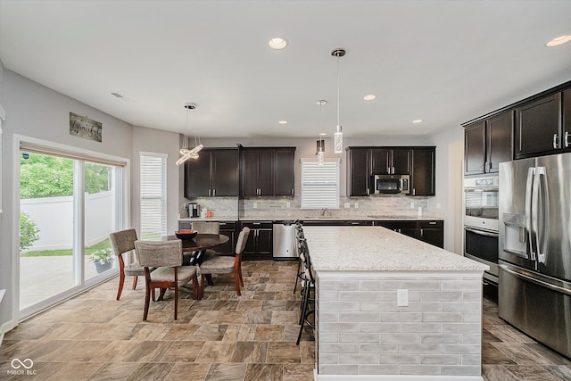 1274 Timber Bluff Rd, Westfield, IN 46074 - kitchen with appliances with stainless steel finishes, tasteful backsplash, a center island, a sink, and decorative light fixtures
