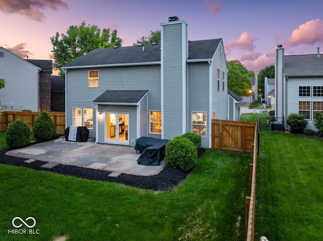5041 Millwright Ct, Indianapolis, IN 46254 - back of house at dusk featuring a patio, a chimney, a gate, and central AC