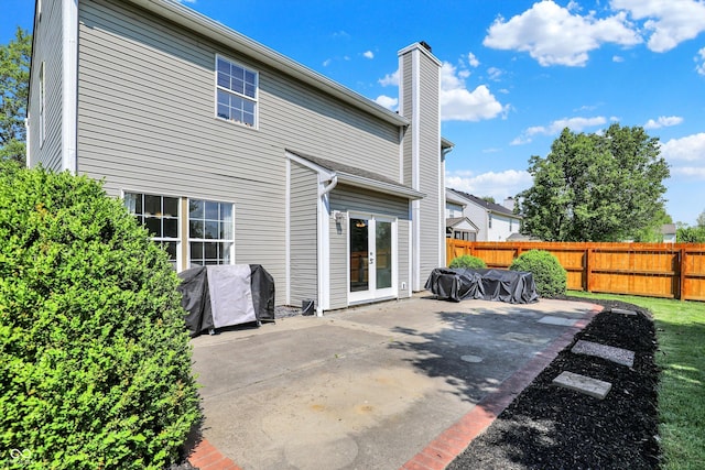 5041 Millwright Ct, Indianapolis, IN 46254 - rear view of house featuring a patio, a fenced backyard, a chimney, and french doors