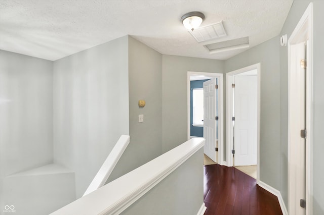 5041 Millwright Ct, Indianapolis, IN 46254 - corridor featuring an upstairs landing, a textured ceiling, attic access, dark wood finished floors, and baseboards