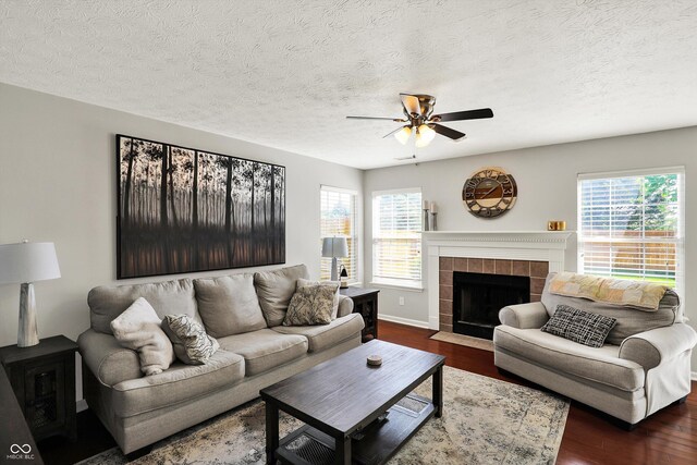 5041 Millwright Ct, Indianapolis, IN 46254 - living room featuring dark wood-style flooring, ceiling fan, a fireplace, a textured ceiling, and baseboards