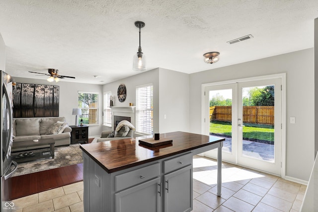 5041 Millwright Ct, Indianapolis, IN 46254 - kitchen featuring wood counters, light tile patterned flooring, baseboards, decorative light fixtures, and a ceiling fan