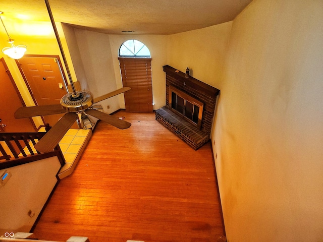 4336 Abby Creek Ln, Indianapolis, IN 46205 - unfurnished living room with wood finished floors, ceiling fan, and a brick fireplace