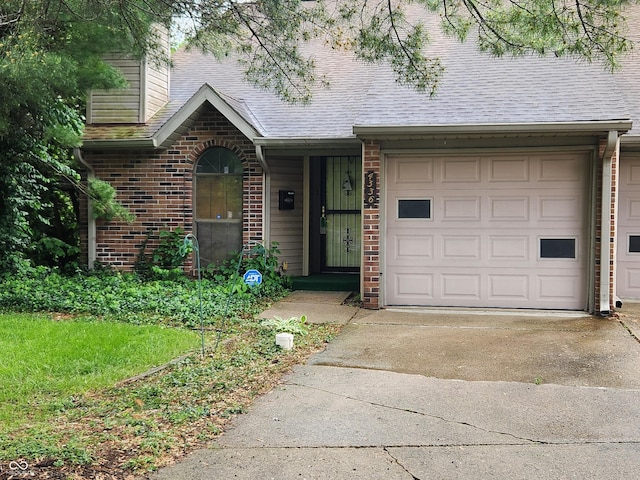 4336 Abby Creek Ln, Indianapolis, IN 46205 - view of front facade featuring driveway, brick siding, a garage, and a shingled roof