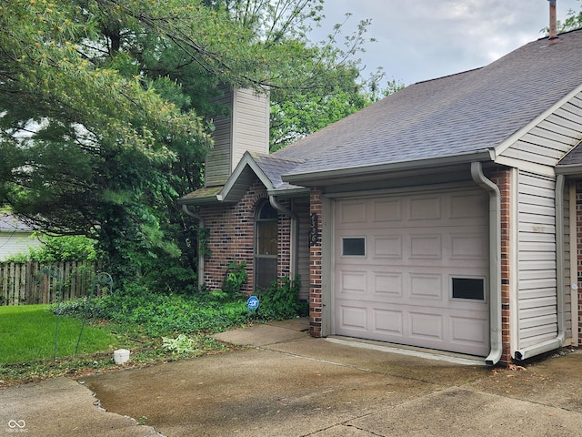 4336 Abby Creek Ln, Indianapolis, IN 46205 - view of home's exterior featuring concrete driveway, a garage, brick siding, a shingled roof, and a chimney