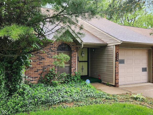 4336 Abby Creek Ln, Indianapolis, IN 46205 - view of front facade featuring an attached garage, roof with shingles, brick siding, and driveway