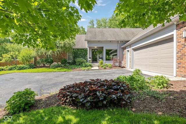 8330 Claridge Rd, Indianapolis, IN 46260 - view of front of property with asphalt driveway, brick siding, a shingled roof, and an attached garage