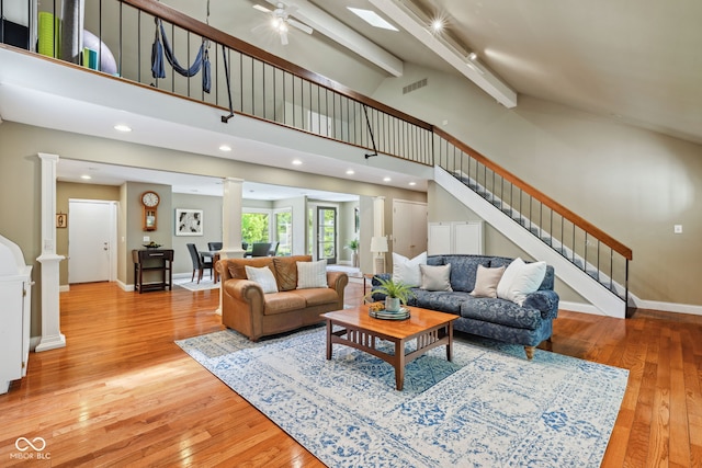 8330 Claridge Rd, Indianapolis, IN 46260 - living room with ornate columns, stairs, light wood-style flooring, high vaulted ceiling, and beam ceiling