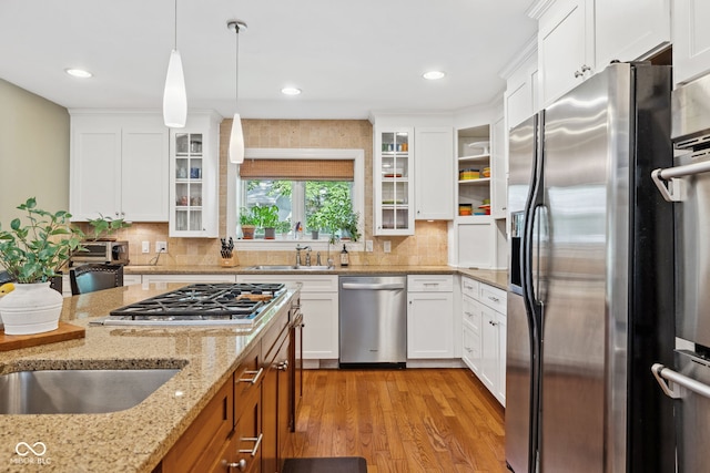 8330 Claridge Rd, Indianapolis, IN 46260 - kitchen featuring stainless steel appliances, a sink, light wood-type flooring, white cabinets, and recessed lighting