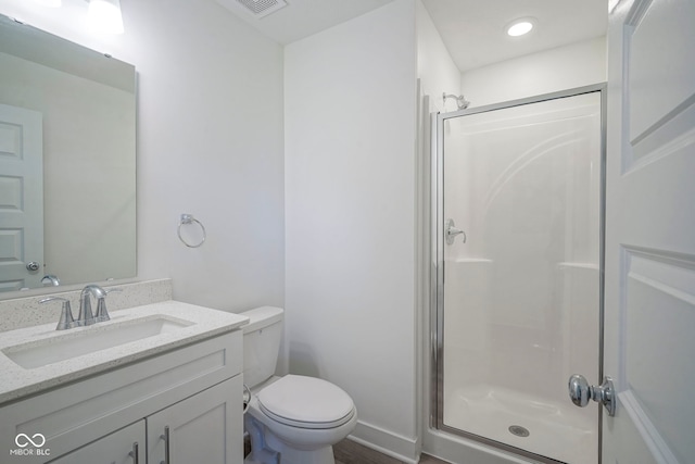 bathroom featuring a shower stall, toilet, and vanity