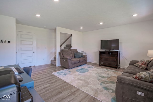 living room featuring wood finished floors, stairs, recessed lighting, and baseboards