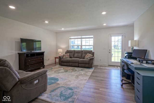 living room with a desk, wood finished floors, baseboards, recessed lighting, and a textured ceiling