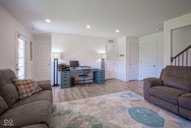 living area featuring light wood-style flooring, an office area, recessed lighting, stairs, and baseboards