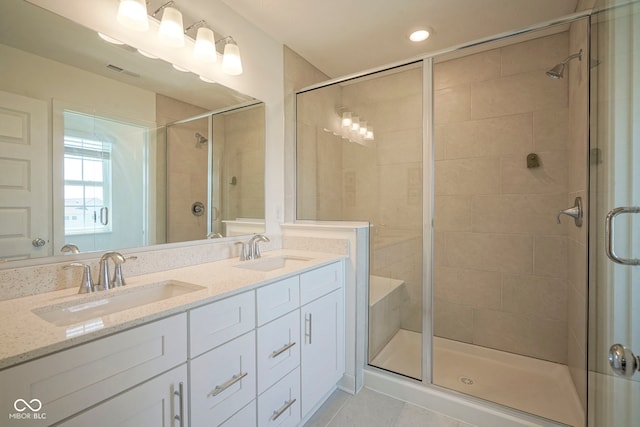 bathroom featuring a stall shower, tile patterned flooring, double vanity, and recessed lighting
