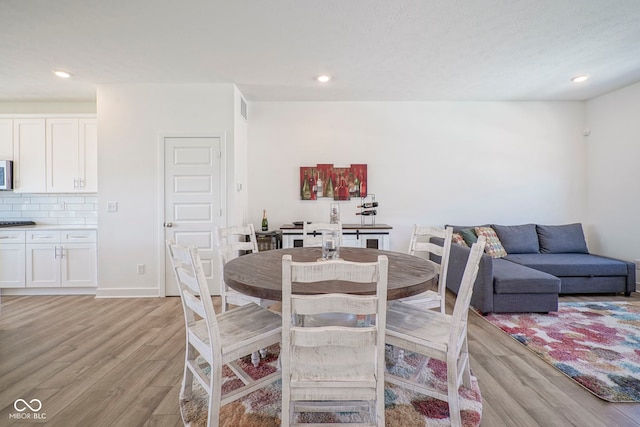 dining room with light wood finished floors and recessed lighting