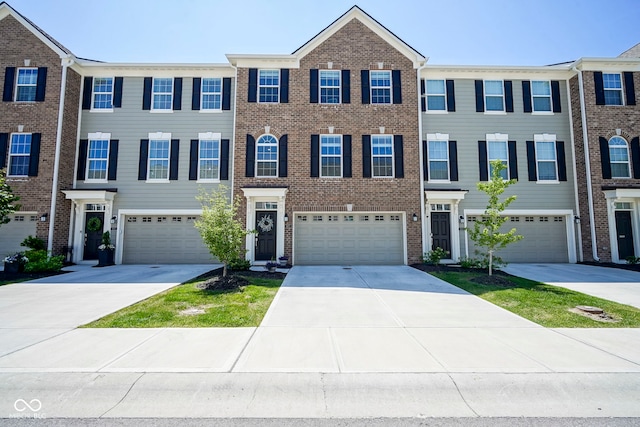 townhome / multi-family property with concrete driveway, brick siding, and an attached garage
