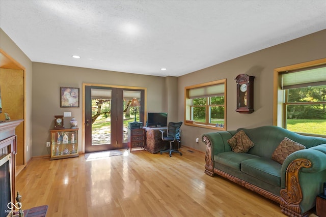 home office featuring plenty of natural light, light wood-style flooring, a fireplace, and recessed lighting