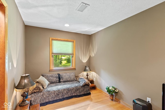 living area with wood finished floors, baseboards, recessed lighting, and a textured ceiling