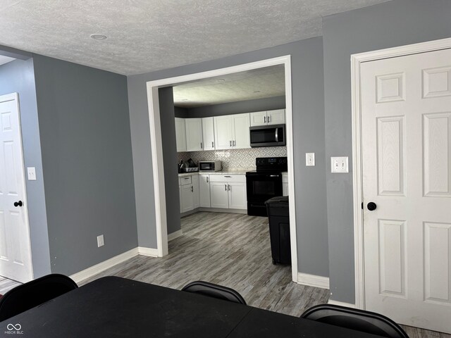 322 S Rural St, Indianapolis, IN 46201 - bedroom featuring light wood-style flooring, baseboards, and a textured ceiling