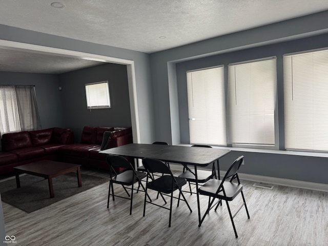 322 S Rural St, Indianapolis, IN 46201 - dining space featuring wood finished floors, a textured ceiling, and baseboards