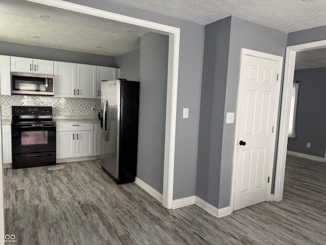 322 S Rural St, Indianapolis, IN 46201 - kitchen featuring appliances with stainless steel finishes, light wood-style flooring, a textured ceiling, and white cabinetry