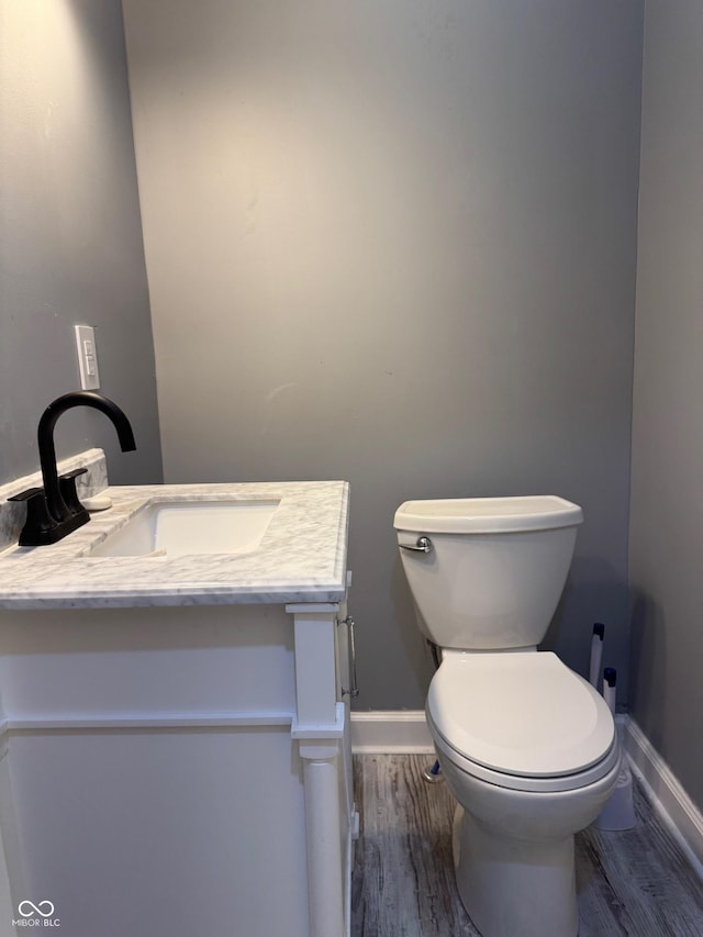 322 S Rural St, Indianapolis, IN 46201 - half bath featuring baseboards, vanity, toilet, and wood finished floors