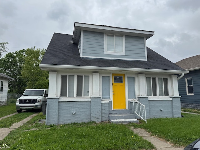322 S Rural St, Indianapolis, IN 46201 - bungalow-style home featuring brick siding, roof with shingles, a front yard, and entry steps
