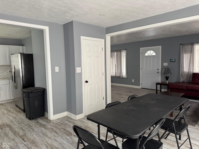 322 S Rural St, Indianapolis, IN 46201 - dining space with light wood-style flooring, a textured ceiling, and baseboards
