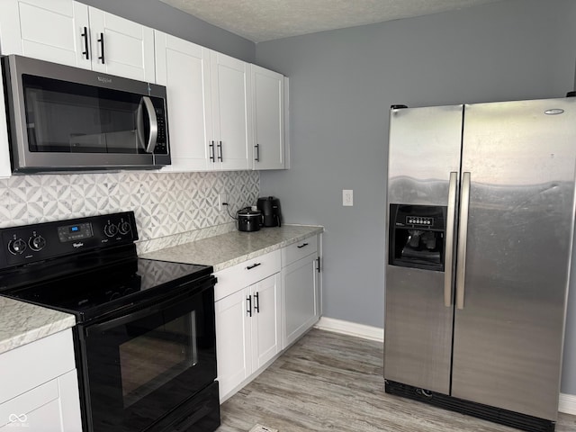 322 S Rural St, Indianapolis, IN 46201 - kitchen featuring stainless steel appliances, decorative backsplash, white cabinets, and light countertops