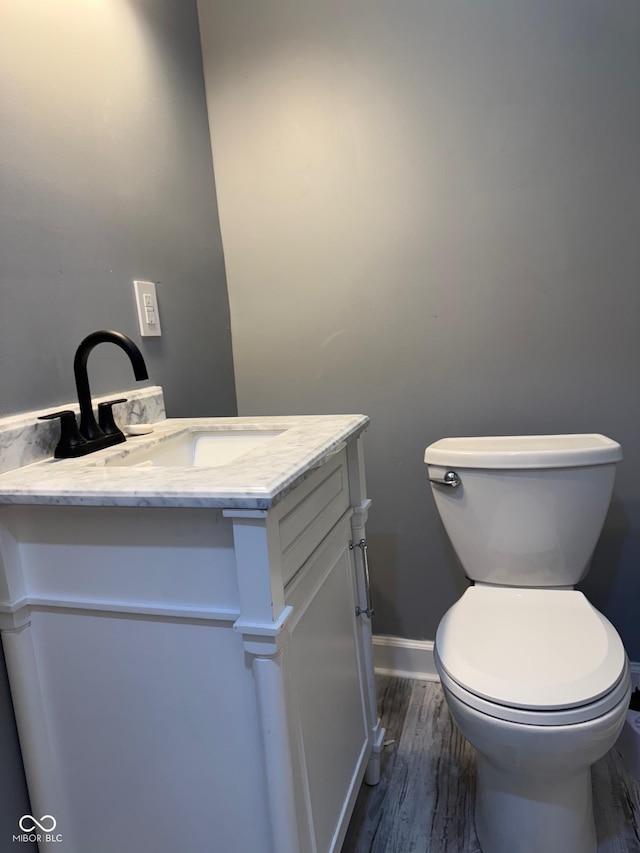 322 S Rural St, Indianapolis, IN 46201 - bathroom featuring vanity, toilet, wood finished floors, and baseboards