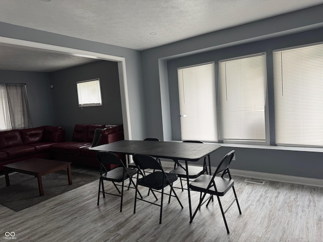 322 S Rural St, Indianapolis, IN 46201 - dining space featuring wood finished floors, a textured ceiling, and baseboards