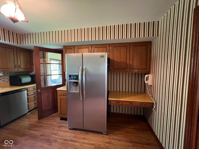3654 W Mecca Rd, Rockville, IN 47872 - kitchen featuring appliances with stainless steel finishes, light wood finished floors, light countertops, and wallpapered walls