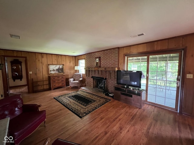 3654 W Mecca Rd, Rockville, IN 47872 - living room with wooden walls, wood finished floors, a brick fireplace, and plenty of natural light