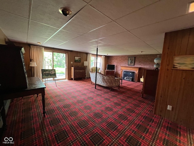 3654 W Mecca Rd, Rockville, IN 47872 - carpeted living room with a fireplace, wood walls, and a drop ceiling