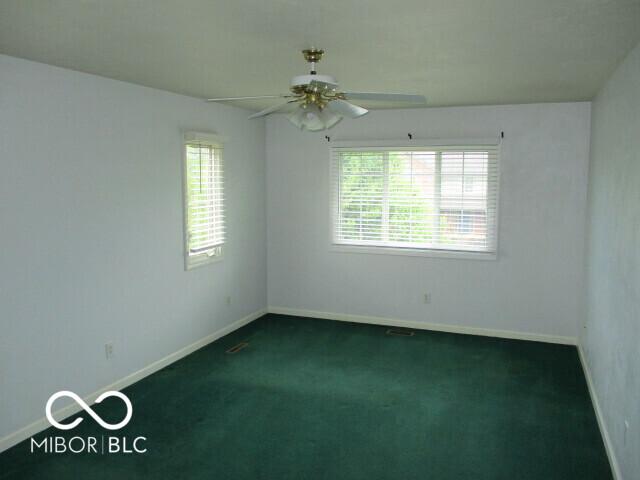4667 Sundance Trl, Indianapolis, IN 46239 - spare room with plenty of natural light, dark carpet, ceiling fan, and baseboards