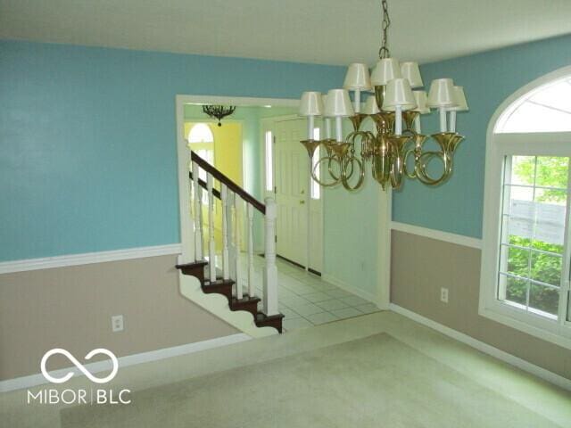 4667 Sundance Trl, Indianapolis, IN 46239 - staircase with a chandelier, baseboards, and carpet flooring