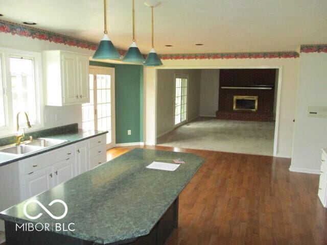 4667 Sundance Trl, Indianapolis, IN 46239 - kitchen featuring a sink, white cabinets, wood finished floors, and healthy amount of natural light