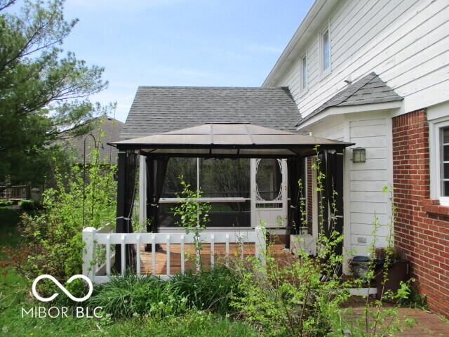4667 Sundance Trl, Indianapolis, IN 46239 - view of home's exterior featuring a gazebo, roof with shingles, and brick siding