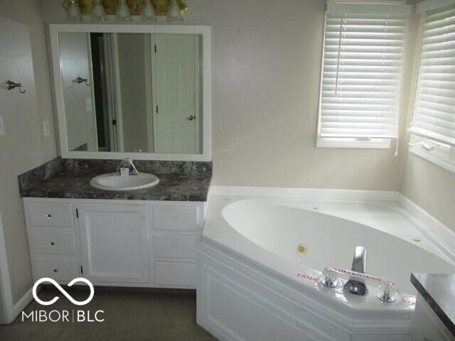4667 Sundance Trl, Indianapolis, IN 46239 - bathroom with vanity and a whirlpool tub