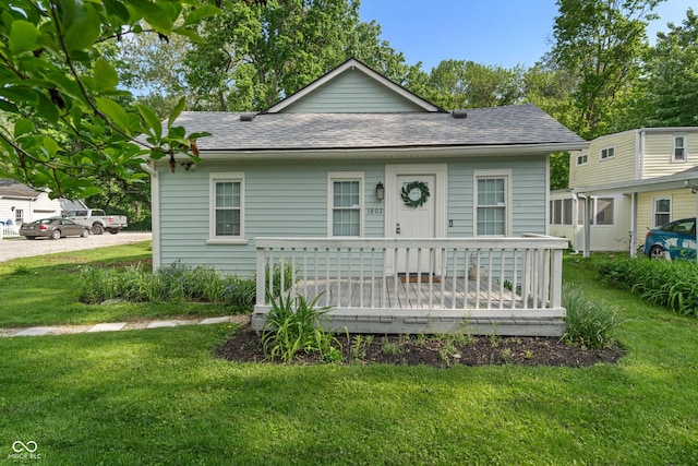 1802 E 66th St, Indianapolis, IN 46220 - bungalow-style house featuring a front lawn, roof with shingles, and a wooden deck