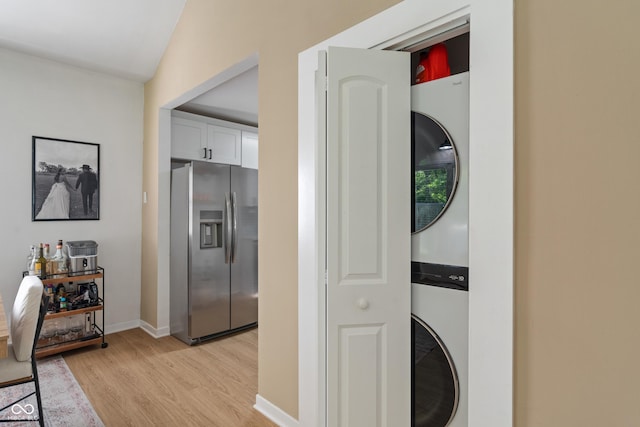1802 E 66th St, Indianapolis, IN 46220 - laundry area featuring stacked washer and clothes dryer, light wood-type flooring, and baseboards