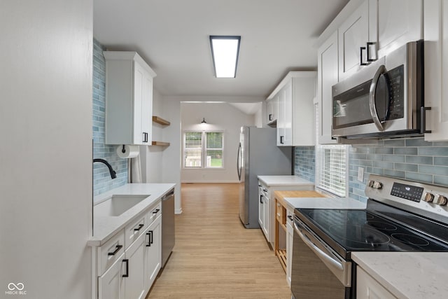 1802 E 66th St, Indianapolis, IN 46220 - kitchen with stainless steel appliances, light wood-style floors, white cabinetry, decorative backsplash, and light stone countertops