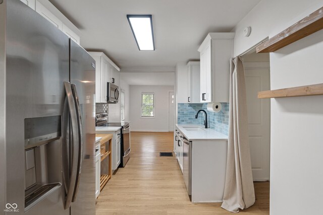 1802 E 66th St, Indianapolis, IN 46220 - kitchen with stainless steel appliances, light countertops, light wood-style floors, and backsplash