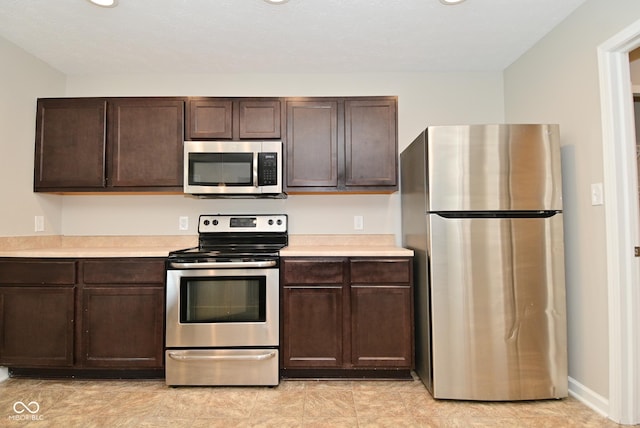 8354 Fieldfare Way, Indianapolis, IN 46237 - kitchen with stainless steel appliances, light countertops, and dark brown cabinets