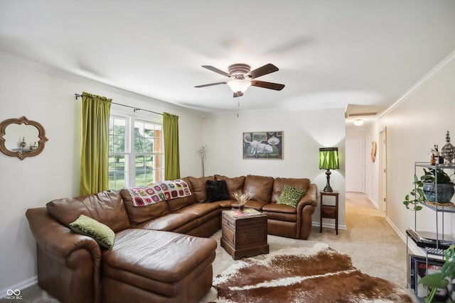 carpeted living area with a ceiling fan, ornamental molding, and baseboards