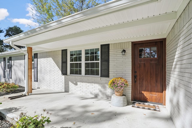 doorway to property featuring brick siding