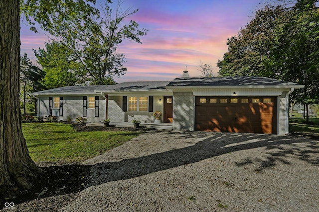 single story home featuring driveway, a garage, and brick siding