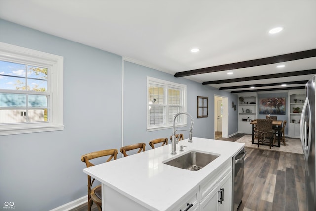 kitchen with a sink, dark wood-type flooring, stainless steel appliances, recessed lighting, and beamed ceiling